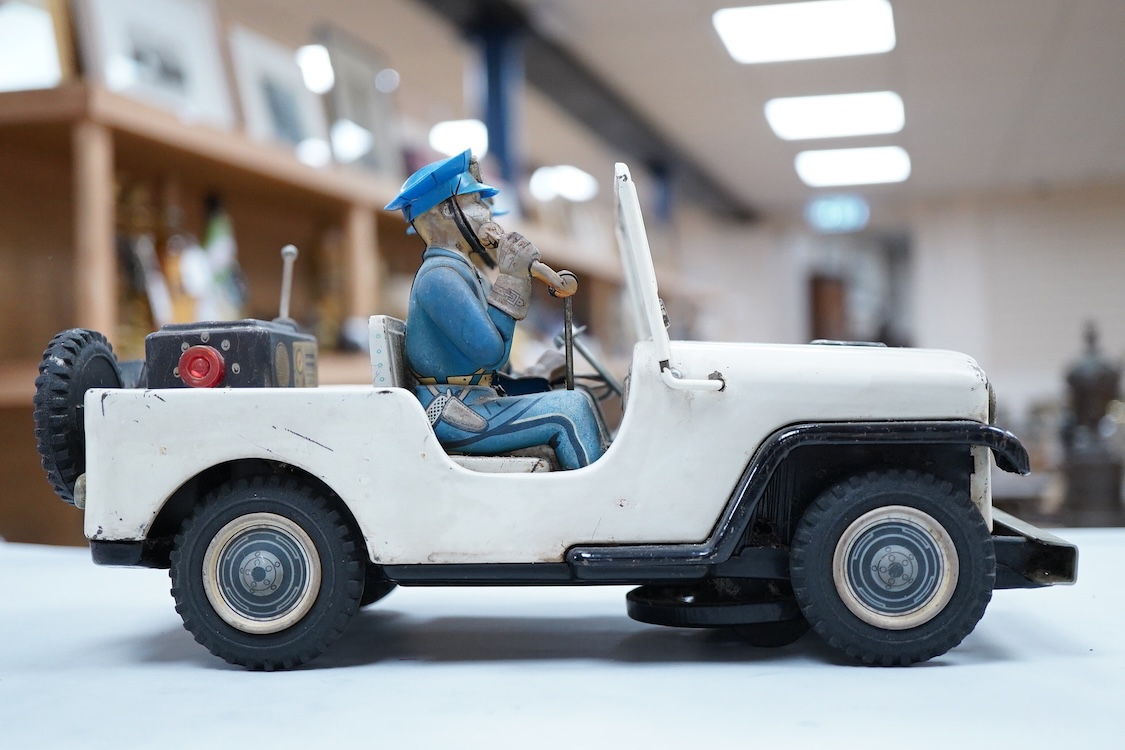 A 1960s Japanese T.N. Nomura battery powered tinplate and plastic Police Department Jeep, impressed manufacturer’s logo and ‘Made in Japan’ to the base